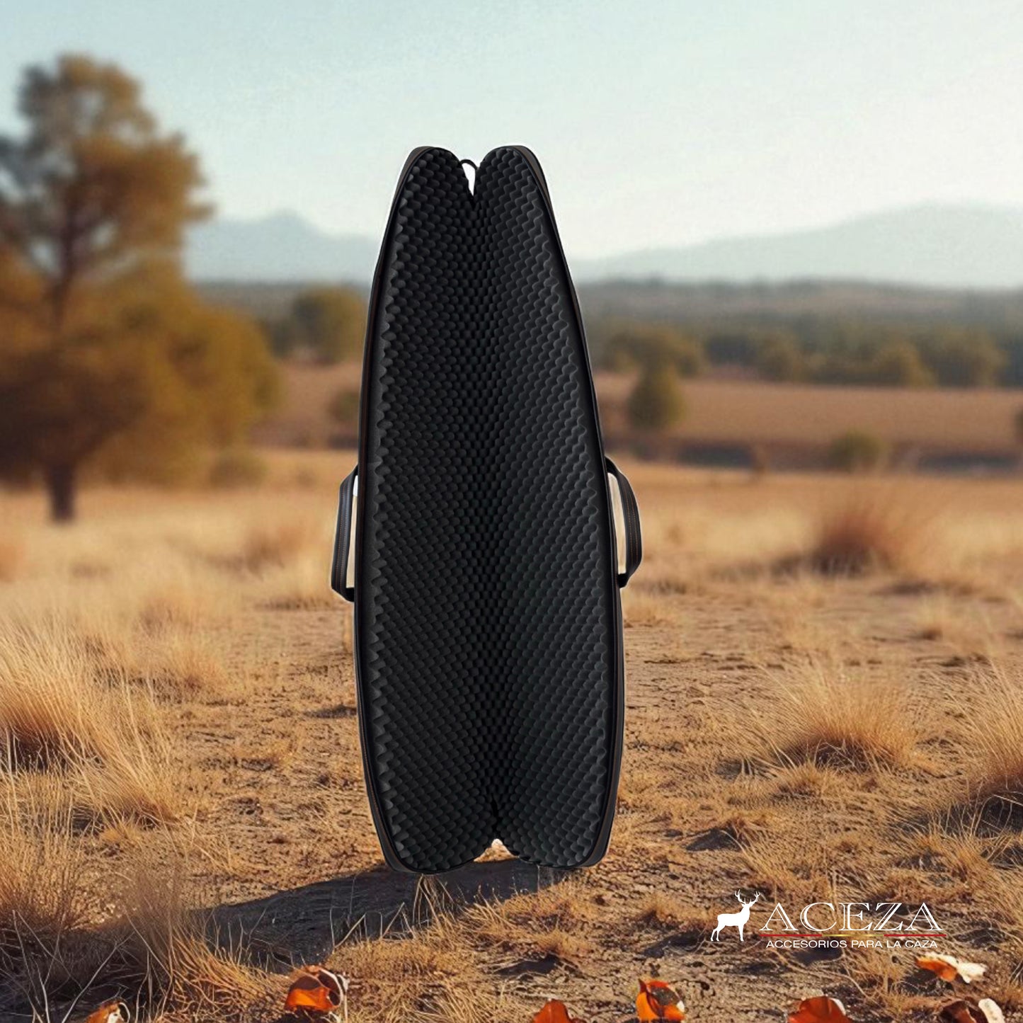 Funda de rifle Aceza abierta en vertical con interior negro, colocada sobre tierra seca con matorrales y paisaje rural al fondo.