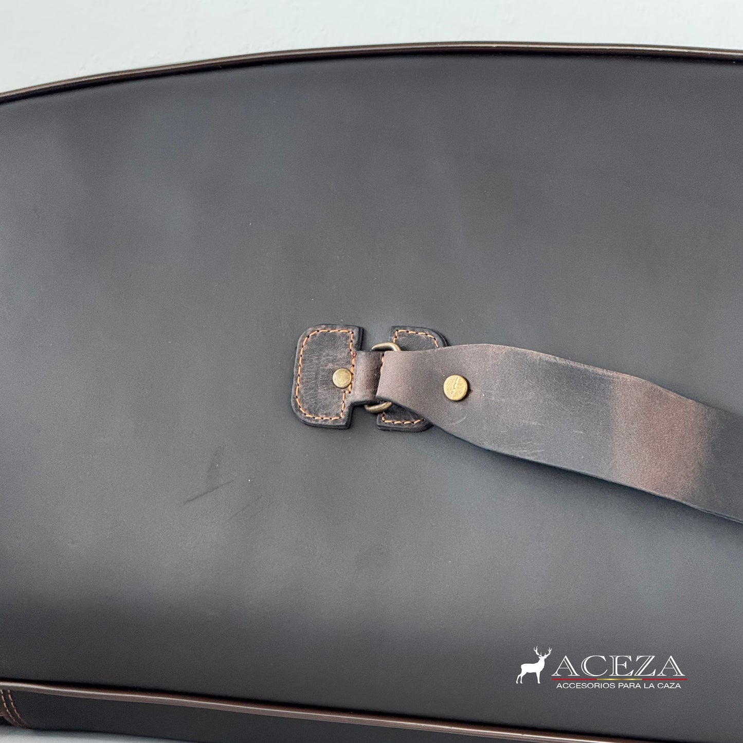 Detalle del sistema de sujeción trasero con correa de cuero y remaches metálicos en funda de rifle Aceza.