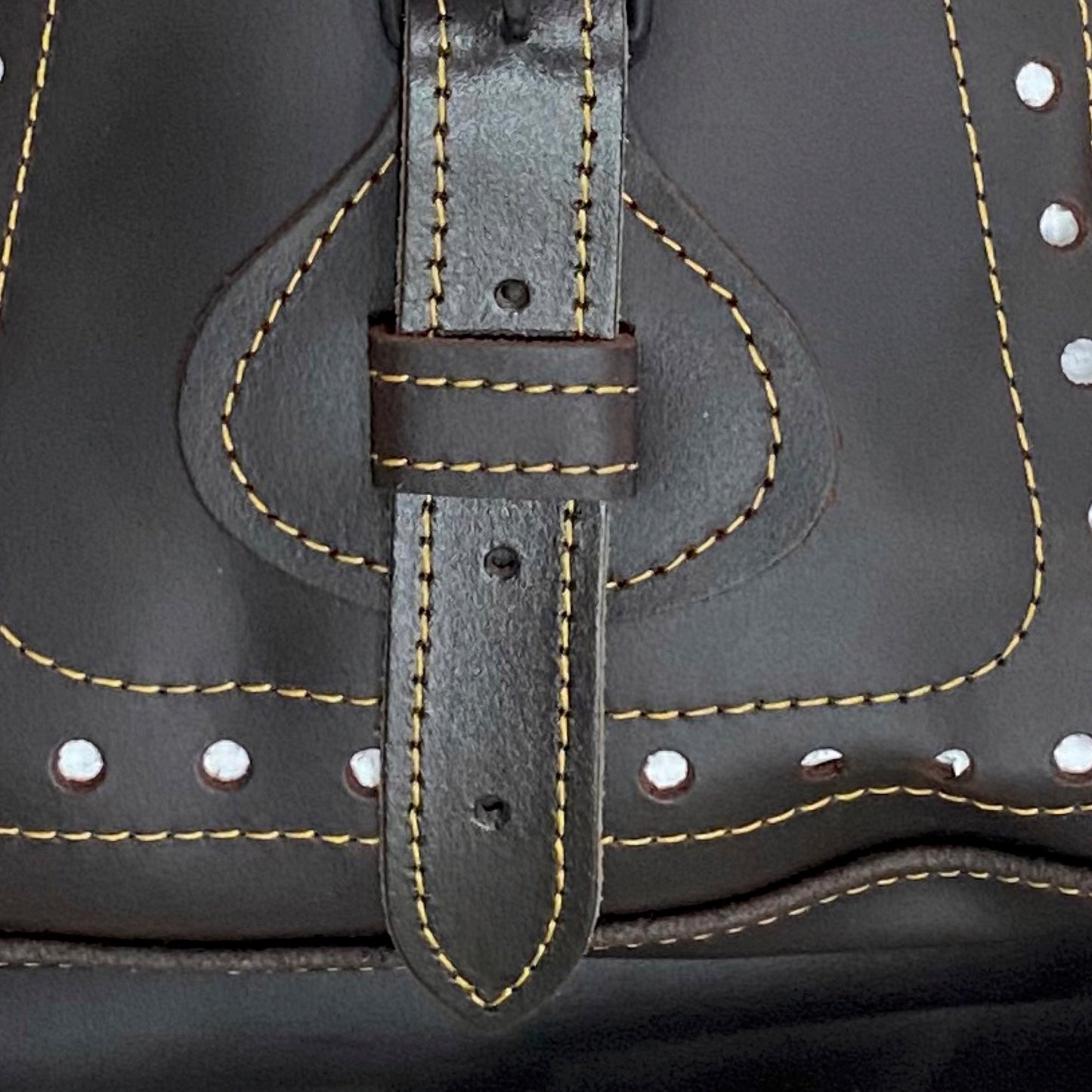 Estilo distintivo en este morral de cuero para cazadores, con una roseta que rinde homenaje a la bandera de España. Equipamiento esencial para cazadores en ACEZA