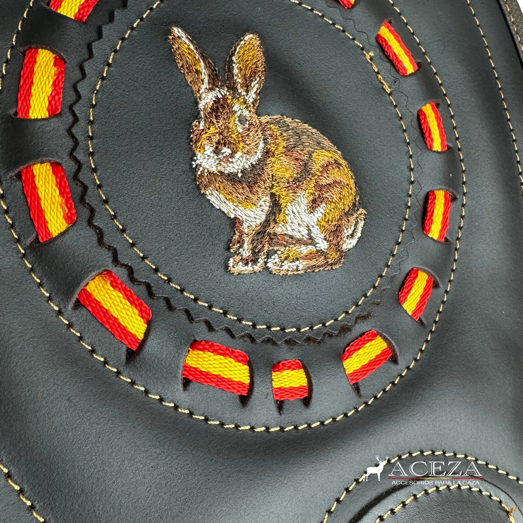 Detalle del bordado del conejo con motivos de la bandera española en la tapa del morral de caza. Añade un toque de tradición a tu equipamiento en ACEZA.